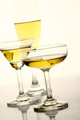 Glasses of alcohol drinks on white.