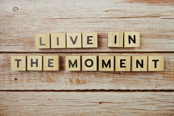 Live In The Moment alphabet letter on wooden background