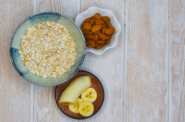 Minimalism in food, ingredients for a healthy breakfast, oatmeal, almond nuts and slices banana fruit