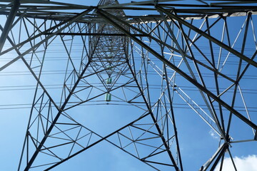 Bottom View of High Voltage Electric Pole with Blue Sky Background.