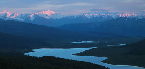 Fototapeta na wymiar Mountain valley in the evening. Peaks in the sunset light, lake.