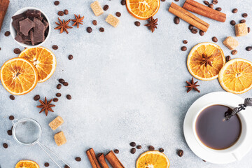 Dried oranges a cup of coffee, cinnamon and spicy spices on a gray background, top view copy space.