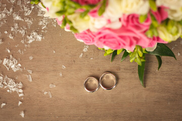 Rings newlyweds on the table next to the bouquet