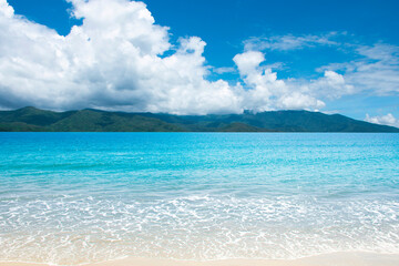 The Scenic beach and mountain view in a Thailand tropical sea at summer season with a calm waves and blue sky for relax in holiday