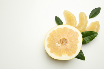 Half of pomelo fruit, slices and leaves on white background