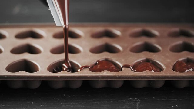 Close-up, melted chocolate poured into a silicone mold, making chocolates, chocolate dessert. Home confectionery.