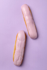Delicious eclairs with custard on violet background
