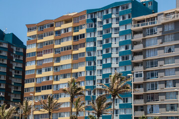 Tall Beachfront Buildings and Palms Against Blue Sky