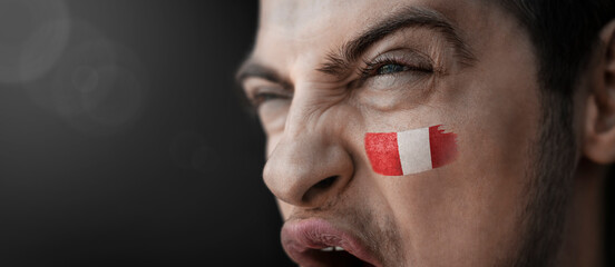 A screaming man with the image of the Peru national flag on his face