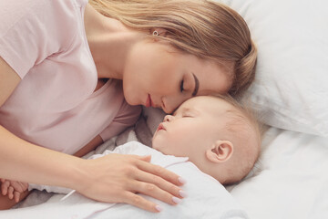 Fototapeta na wymiar Mother with cute little baby sleeping on bed
