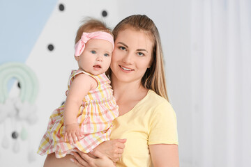 Happy mother with cute little baby at home