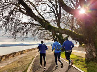 runners run sunset beams trees in winter eveing in ioannina greece