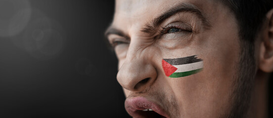 A screaming man with the image of the Palestine national flag on his face