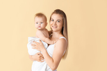 Happy mother with cute little baby on color background