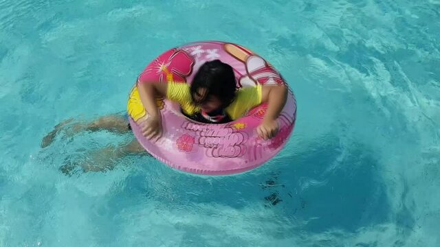 kid with swim ring in swimming pool