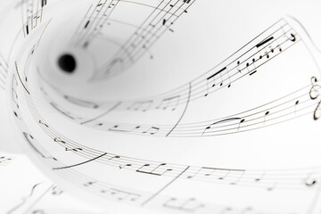 Rolled paper sheet with music notes, closeup