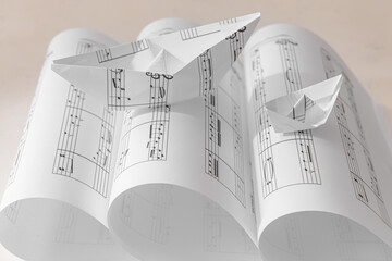 Paper boat with notes on rolled music sheets