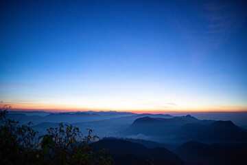 Sunrise over the mountains standing in fog on the island of Sri Lanka.