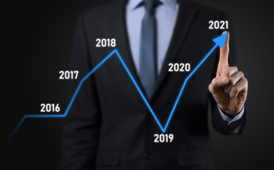 Businessman on a black background presses, presses a finger on a positive growth arrow. Graphs of indicators. Business development and finance concept