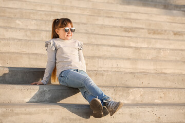 Cute little girl with stylish sunglasses outdoors