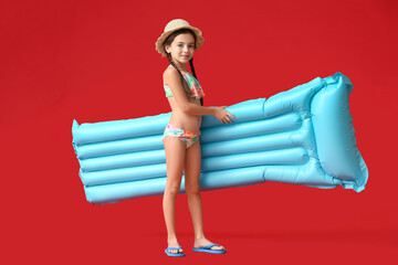 Cute little girl with inflatable mattress on color background
