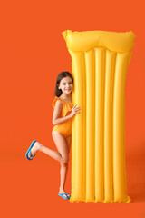 Cute little girl with inflatable mattress on color background