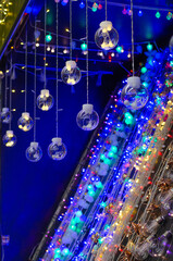 Electric garlands glowing on the counter of the store. Small lamps for sale. Christmas lights.