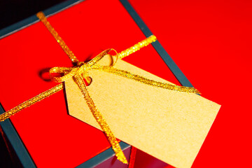 Gift box with a label for the text, red background, view from above.