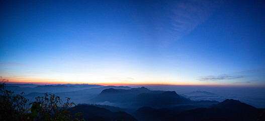Sunrise over the mountains standing in fog on the island of Sri Lanka.