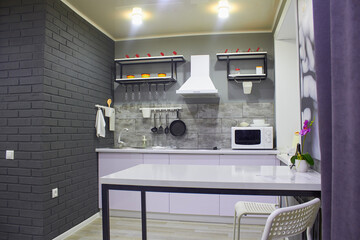 Interior of a modern kitchen. Small but cozy kitchen. In the foreground is a table.