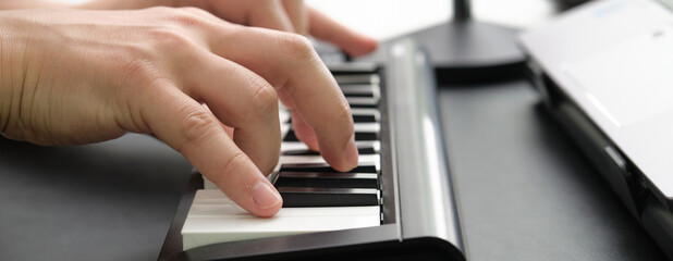 Fototapeta na wymiar Hands playing the electronic piano. Web banner.