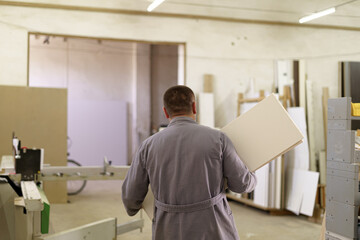 Man carpenter working with wood in his workshop