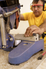 Male carpenter using saw for cutting wood at workshop