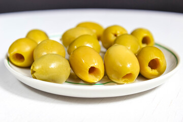 Pitted olives in a saucer close up.