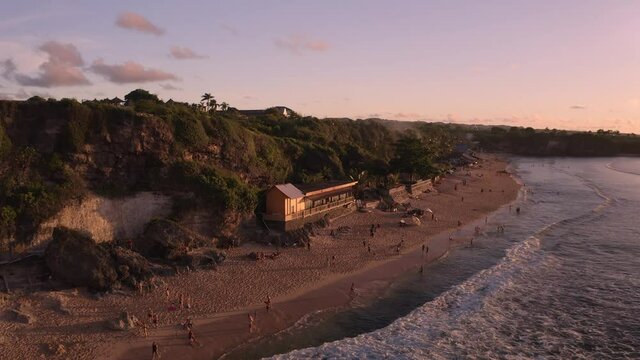 Flying past Tebing Pantai Balangan with tourist taking pictures during sunset