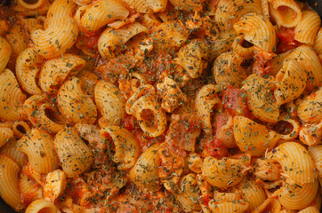 Pasta with spicy tomato sauce, parmesan and basil as background