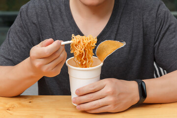 Work from home,Businessman working remotely from home. Using computer and eating cup noodle....