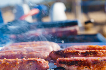 Sausages meat grilling on gas grill