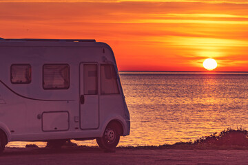 Camper vehicle on beach at sunrise