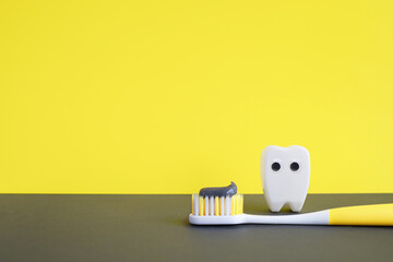 Illuminating yellow toothbrush with toothpaste and white toy tooth on ultimate gray background....