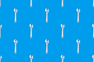 Adjustable metal wrench seamless pattern. Adjustable metal wrench on a colored background.