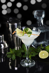 Tequila, Citrus liquor, lime juice - this is a Margarita cocktail. A  of lime with a sprig of mint decorates a glass. Dark  moody food