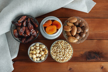 Different delicious nuts and dried fruit on wooden table. Top view. Healthy food and snack