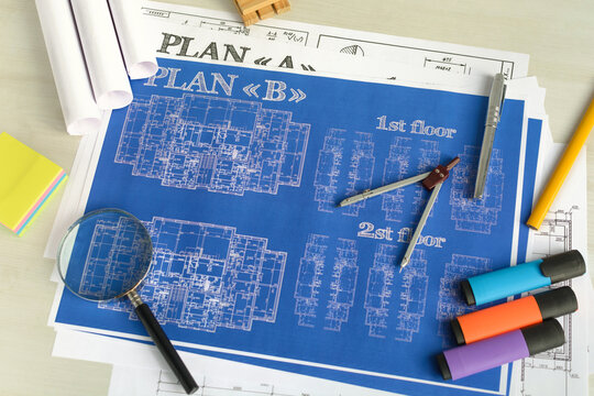 Business accessories (laptop, smartphone, pens, magnifier), accessories for drawing (plans, rulers) and learning on the table