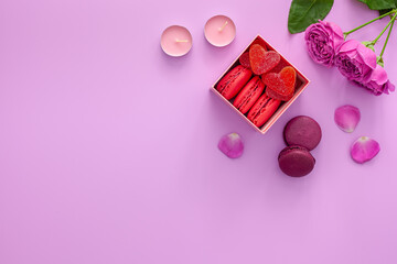 Fototapeta na wymiar Valentine's day concept. Pink gift box with marmalade and macaroons and a beautiful rose on a pink background
