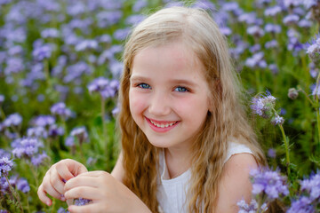 portrait of a little girl in a purple field with flowers