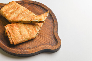 Lavash with suluguni cheese inside. Delicious snack. Served on a wooden board over white background.