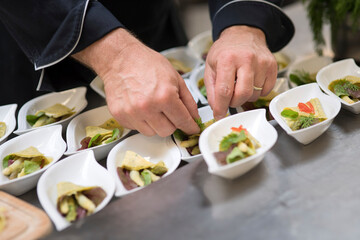 Catering Buffet Partyservice Essen zubereiten von einem Koch auf kleine Teller