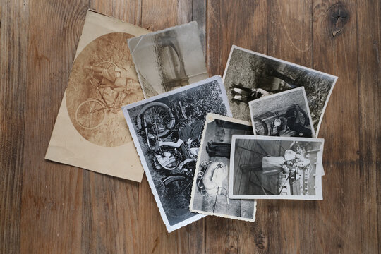 stack of old vintage monochrome photographs on photographic paper on natural wood background, concept of genealogy, the memory of ancestors, family tree
