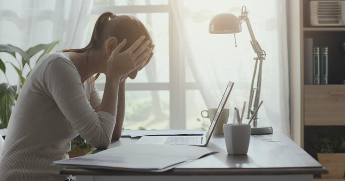 Exhausted Woman With Headache Working In Her Office